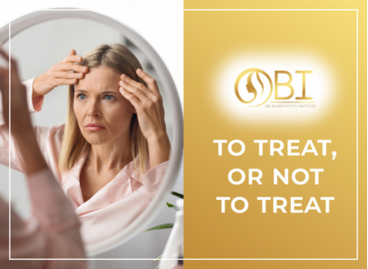 Woman examining facial fine lines in a mirror, illustrating the dilemma of choosing aesthetic treatments at OBI Bioaesthetic Institute